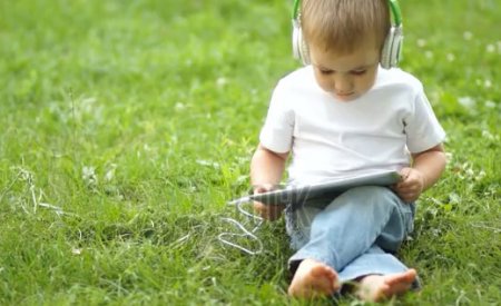 دانلود فوتیج گوش دادن به موسیفی توسط پسر بچه کوچک در پارک
